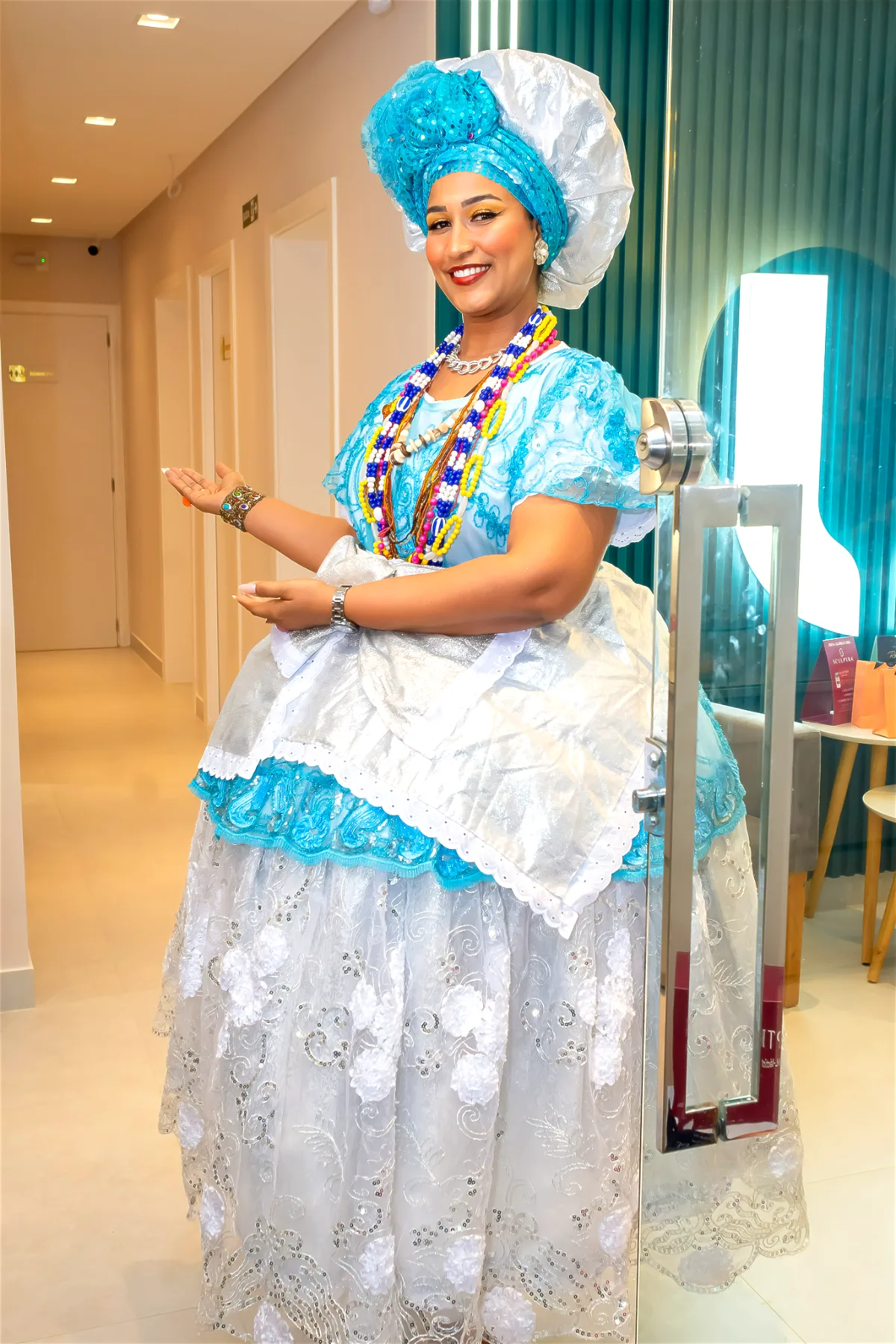 Baiana com vestido tradicional azul e branco recebendo convidados na Nubelle Salvador